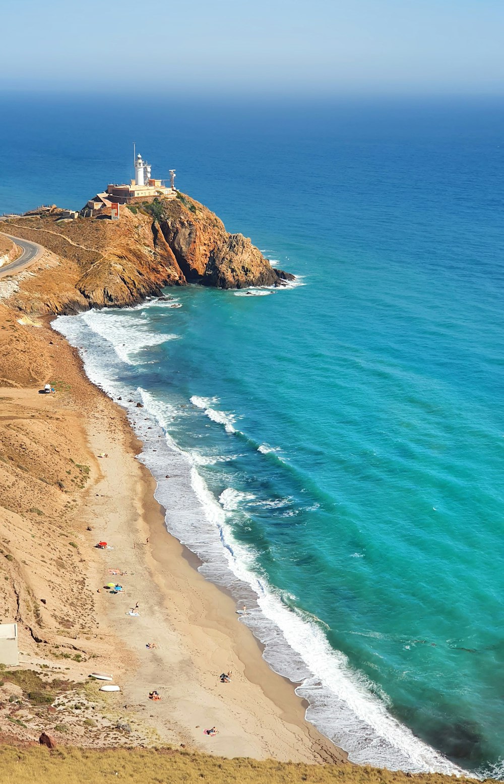 white and brown concrete building on brown sand beach during daytime