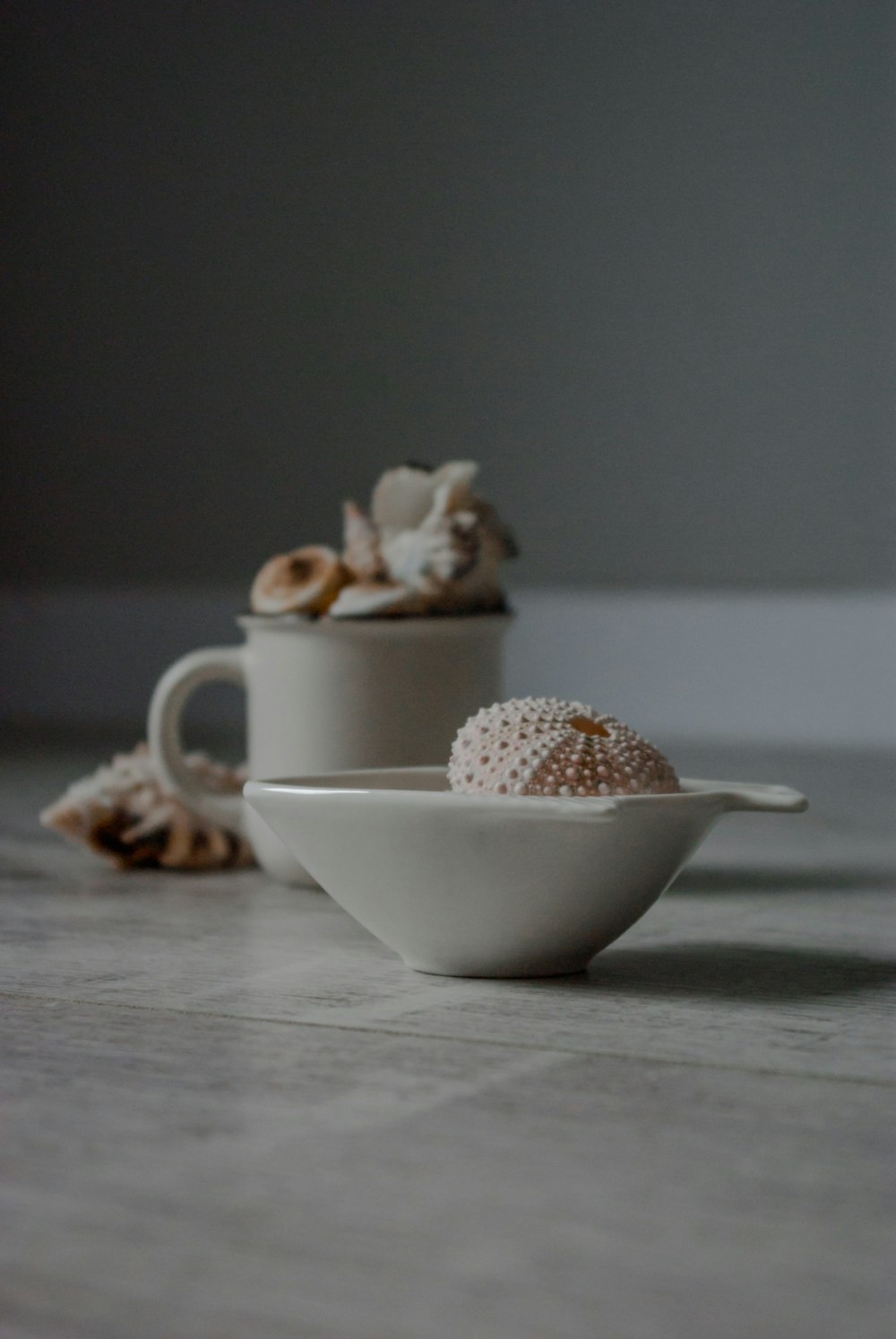 white ceramic teacup with brown and white beads on white ceramic saucer