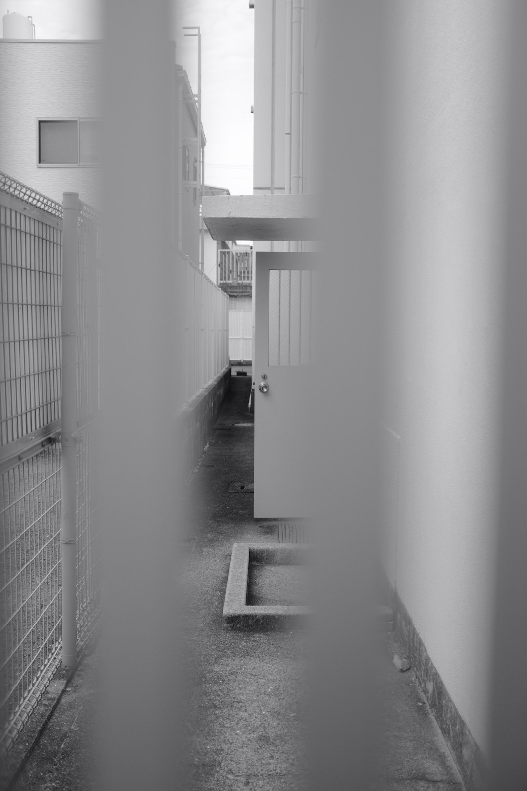 grayscale photo of hallway with white wall