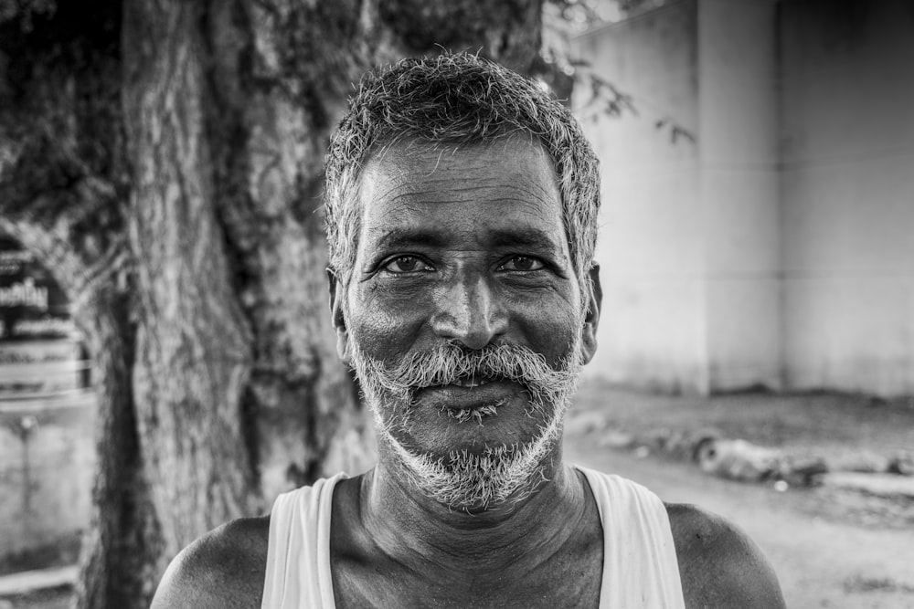 man in tank top in grayscale photography