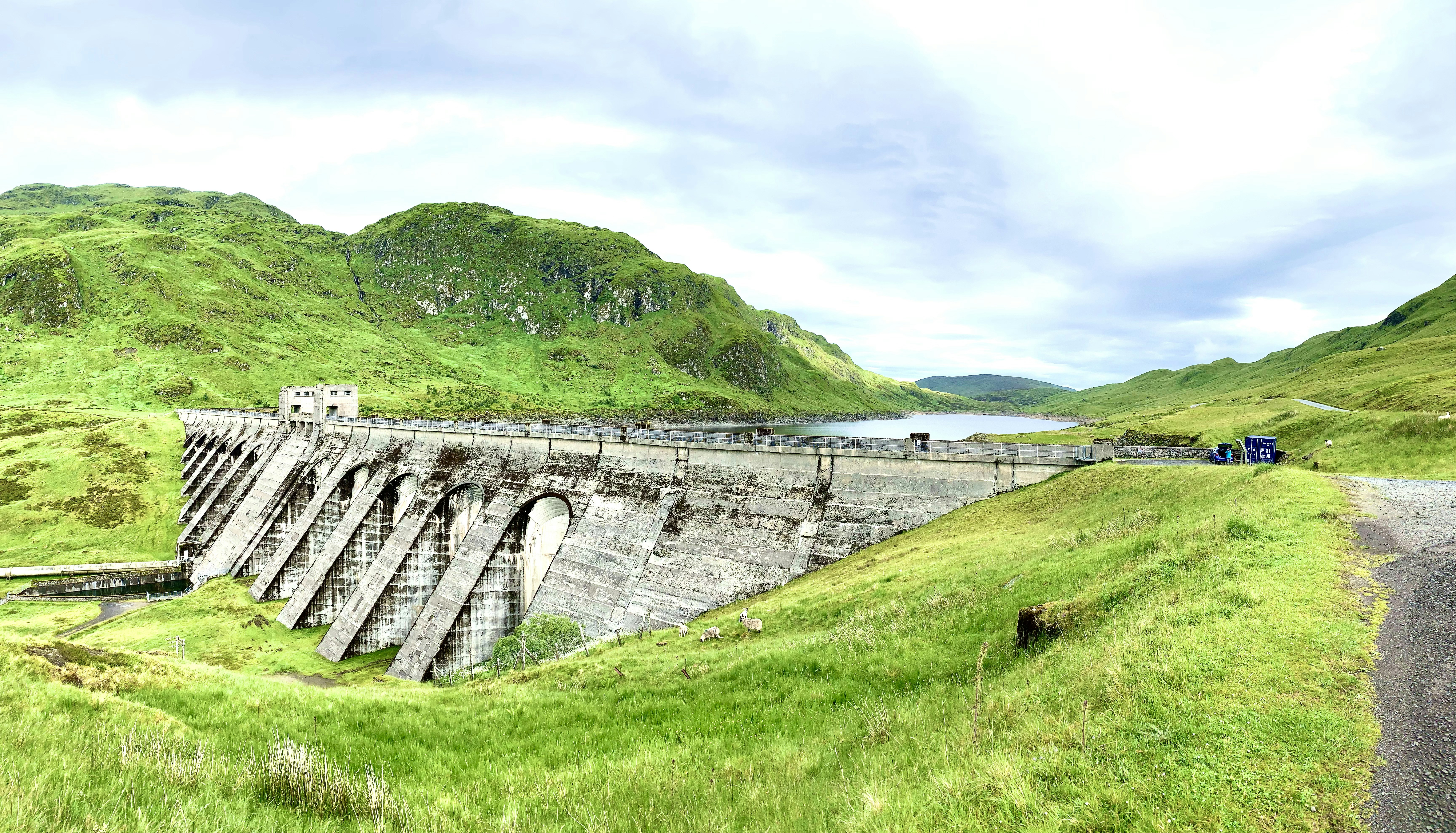 pont en béton gris sur un champ d’herbe verte pendant la journée