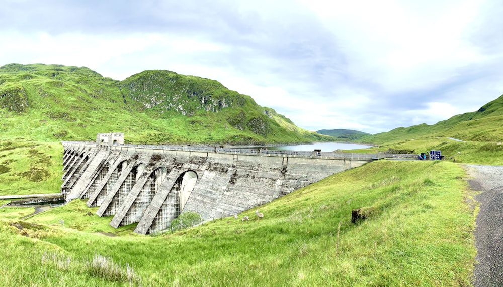 gray concrete bridge on green grass field during daytime