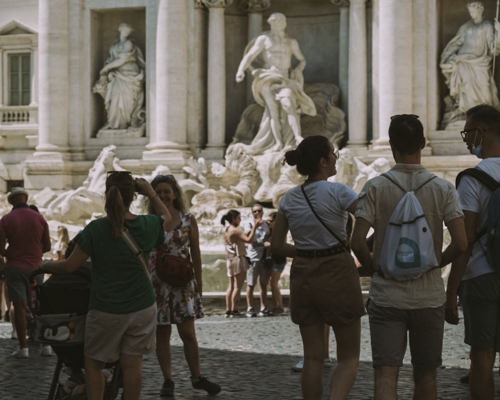 people walking on street near statue during daytime