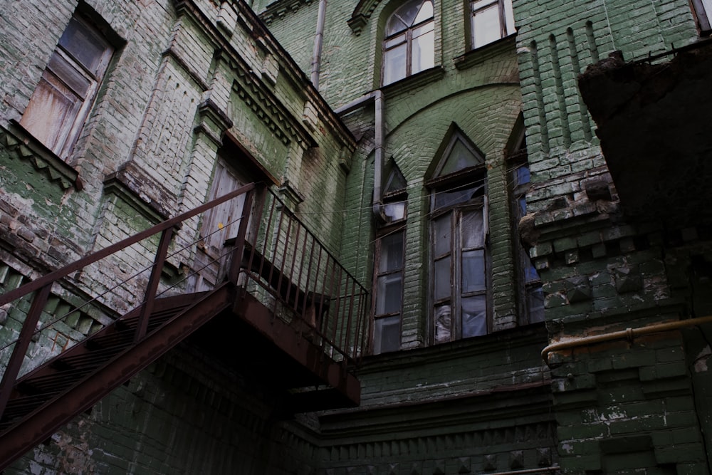 brown wooden staircase on gray brick building