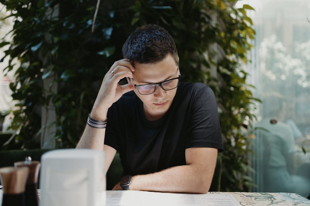 man in black crew neck t-shirt wearing black framed eyeglasses