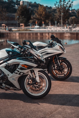 white and black sports bike parked on gray concrete road during daytime