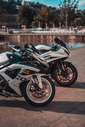 white and black sports bike parked on gray concrete road during daytime
