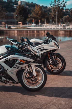 white and black sports bike parked on gray concrete road during daytime