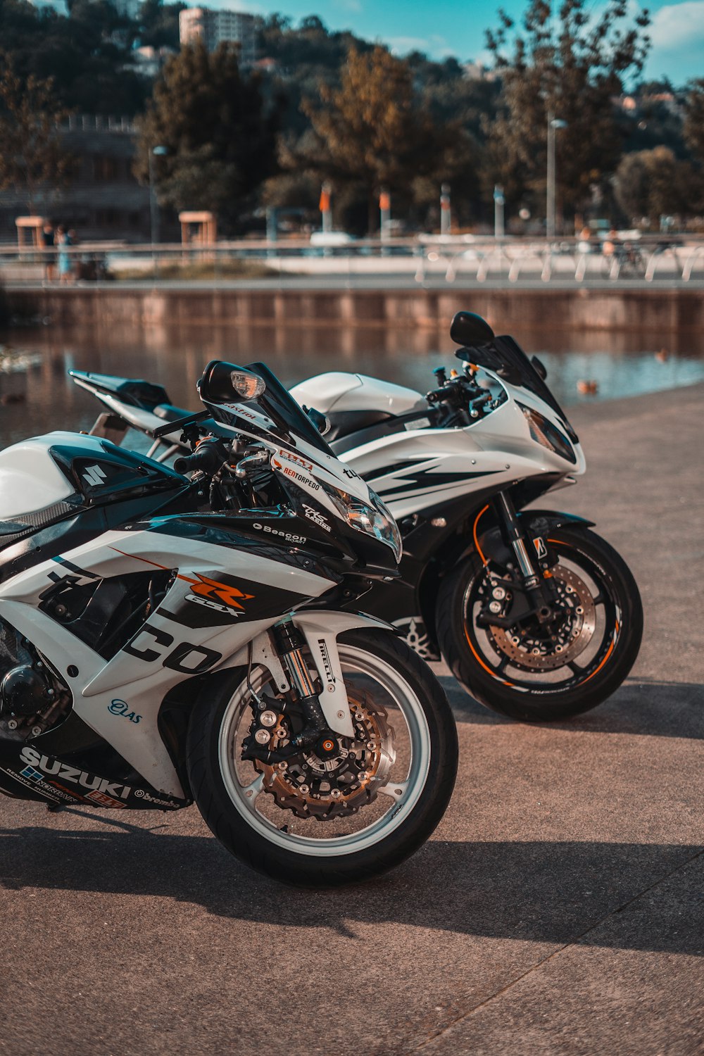 white and black sports bike parked on gray concrete road during daytime