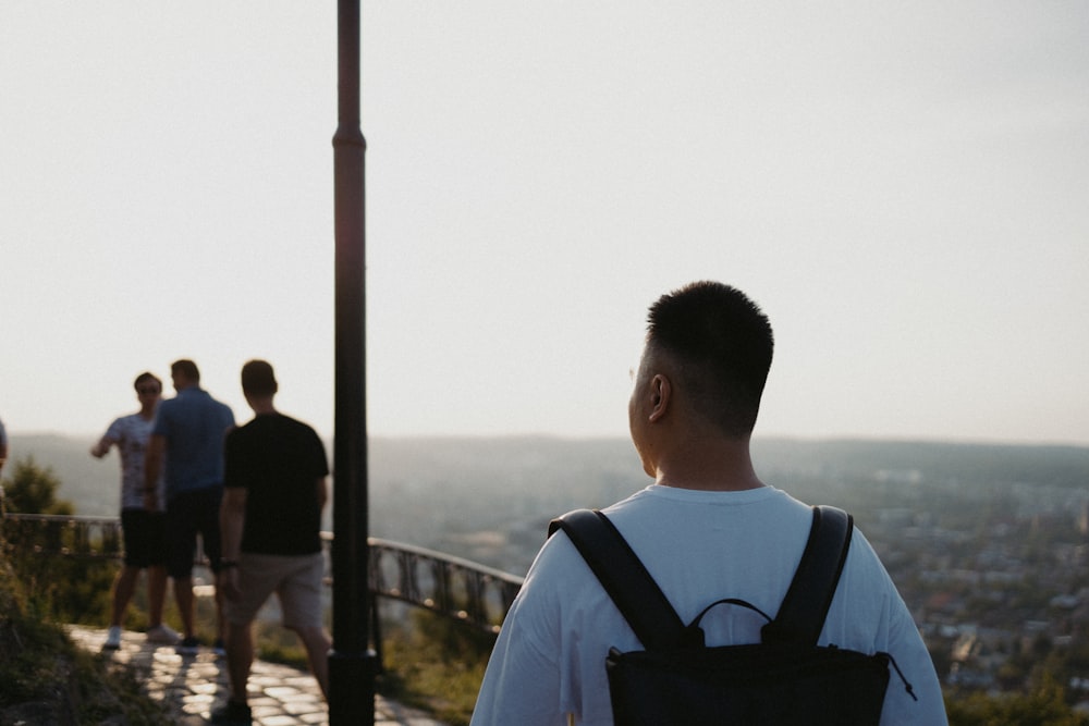 man in black and white crew neck shirt standing near body of water during daytime