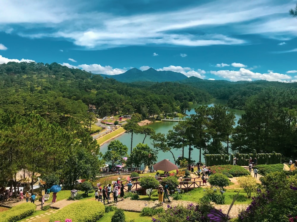 昼間、緑の木々や山の近くの公園を歩く人々