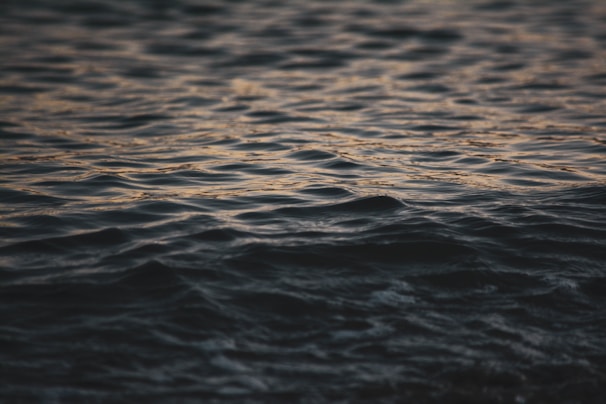 A close-up of rippling water surface with soft glowing waves, embodying the purity and fluidity of Aquarive.