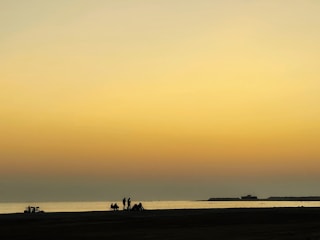 A serene beach scene at sunset, inviting calm and reflection for wellness travelers.