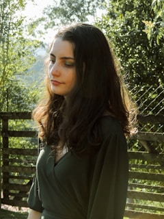 A serene woman in her 50s enjoying a peaceful moment in a sunlit garden, symbolizing calm during menopause.