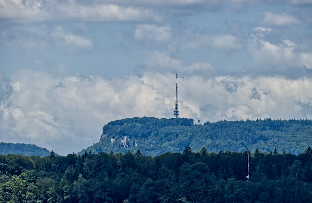 green trees on mountain under cloudy sky during daytime