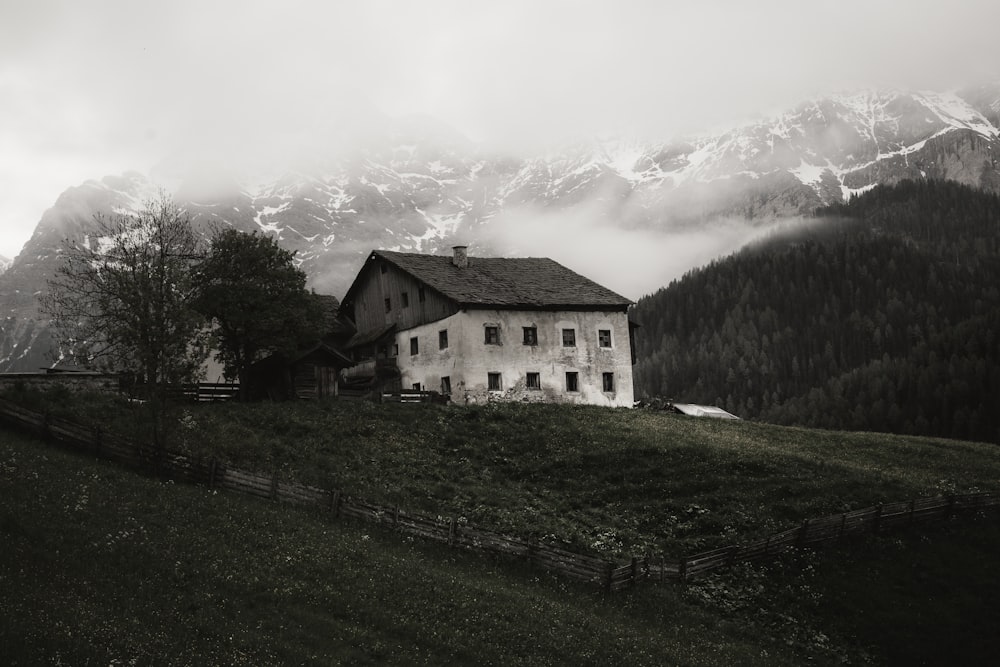 white concrete building near green grass field and mountain