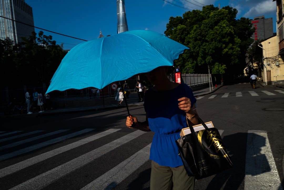 woman in blue dress holding blue umbrella