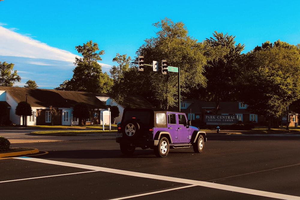 purple and black suv on road during daytime