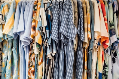Display of colorful casual shirts hanging on a rack in a boutique.