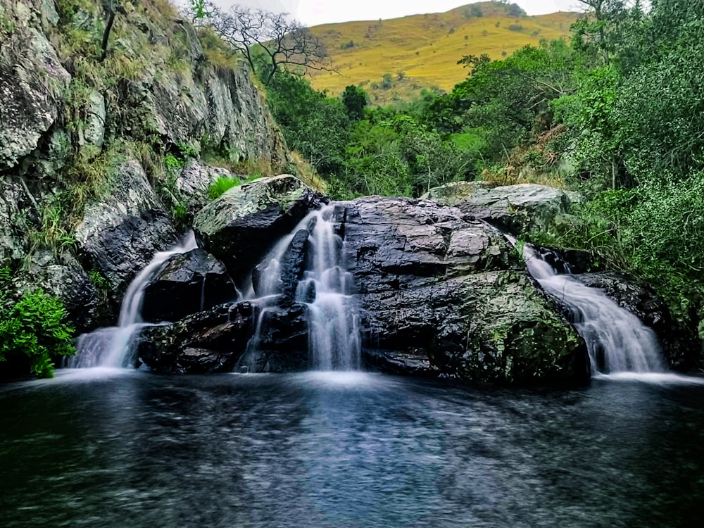 waterfalls on green grass covered hill during daytime