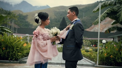 man in black suit holding woman in pink dress