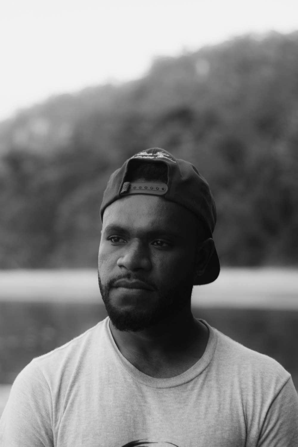 man in white crew neck shirt wearing black fitted cap