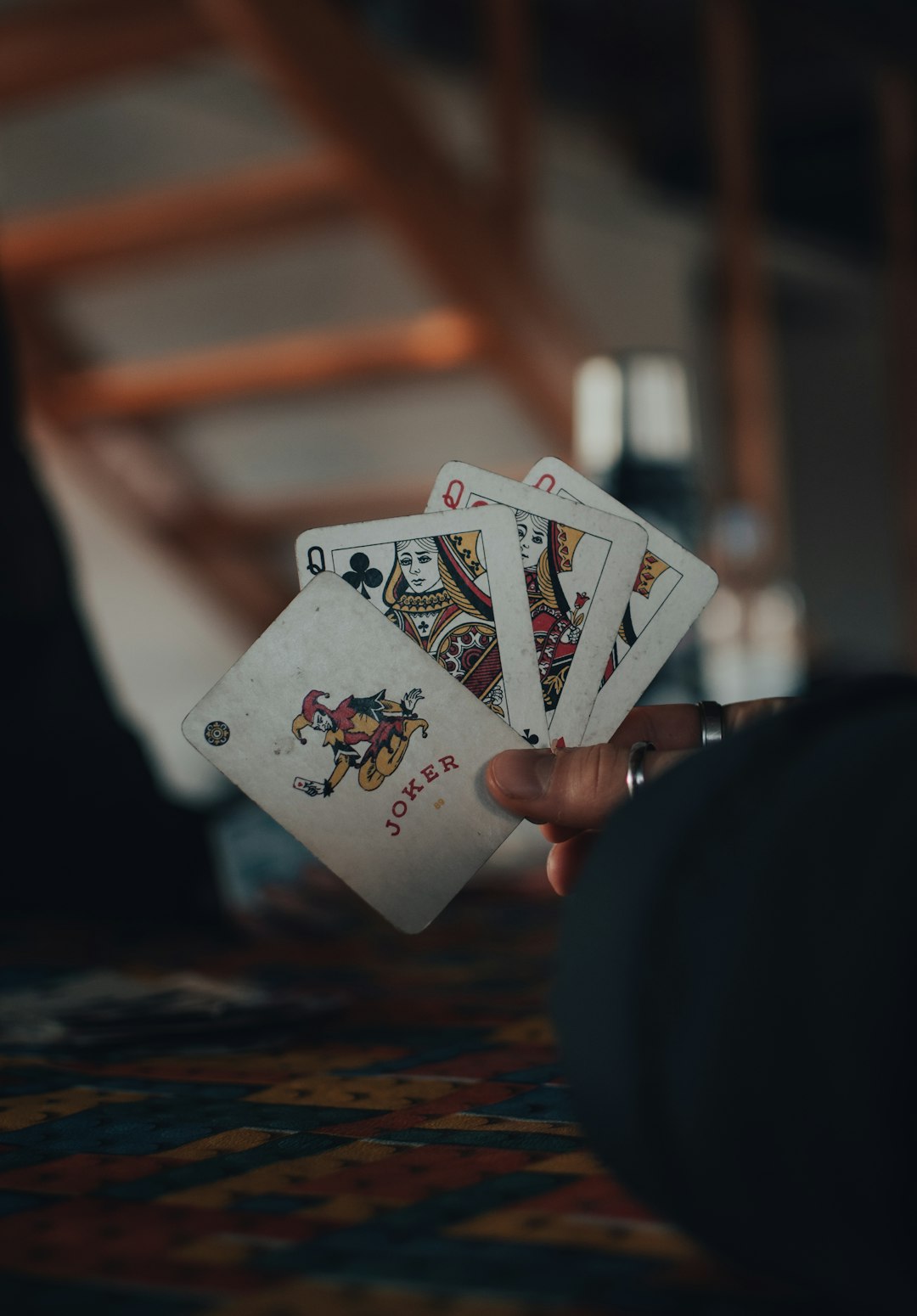 person holding 6 of hearts playing card