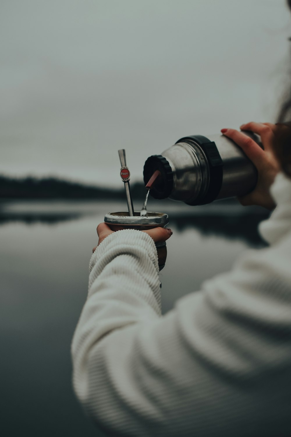 person in white jacket holding black and silver dslr camera