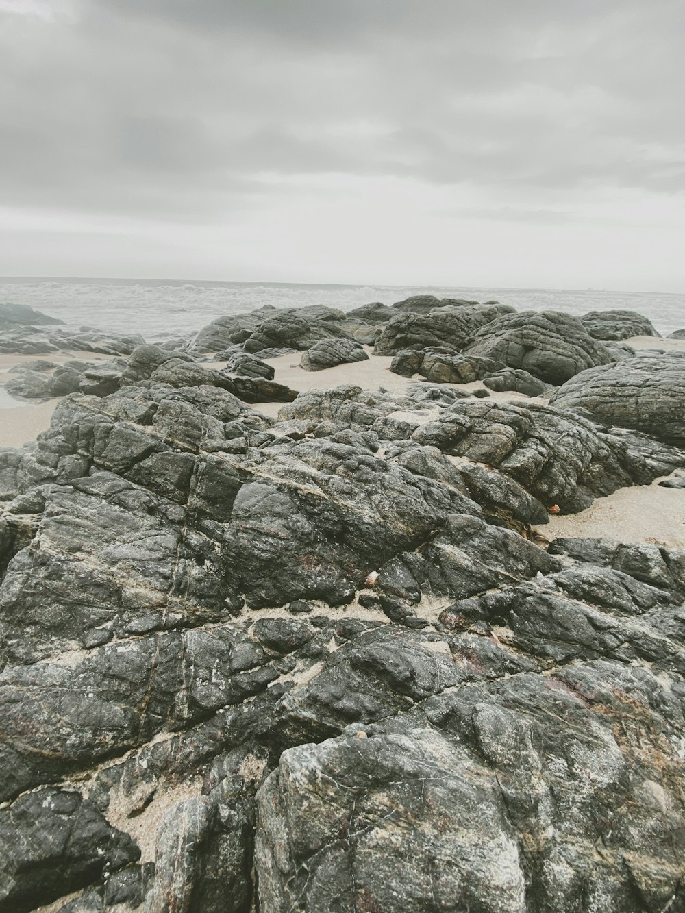 gray rocky mountain near body of water during daytime