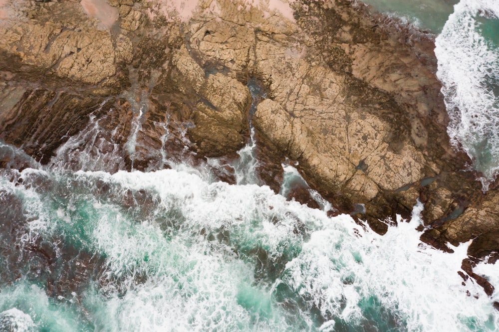 Montaña rocosa marrón junto al cuerpo de agua durante el día