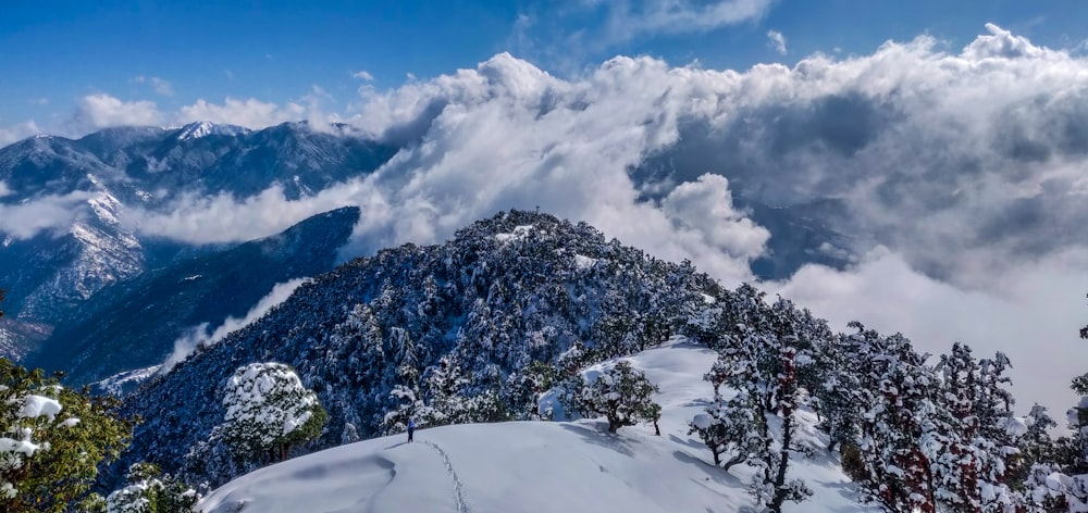 snow covered mountain under white clouds during daytime