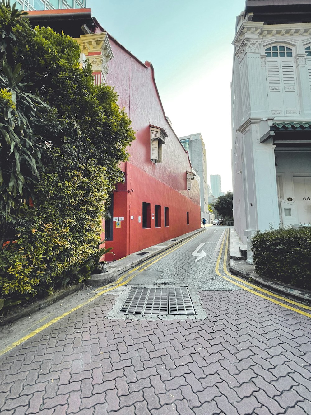 red and white concrete building beside green trees during daytime