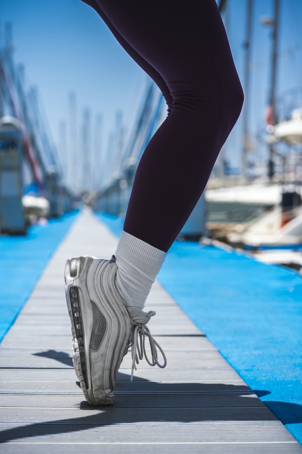 person in black pants and white and black nike sneakers