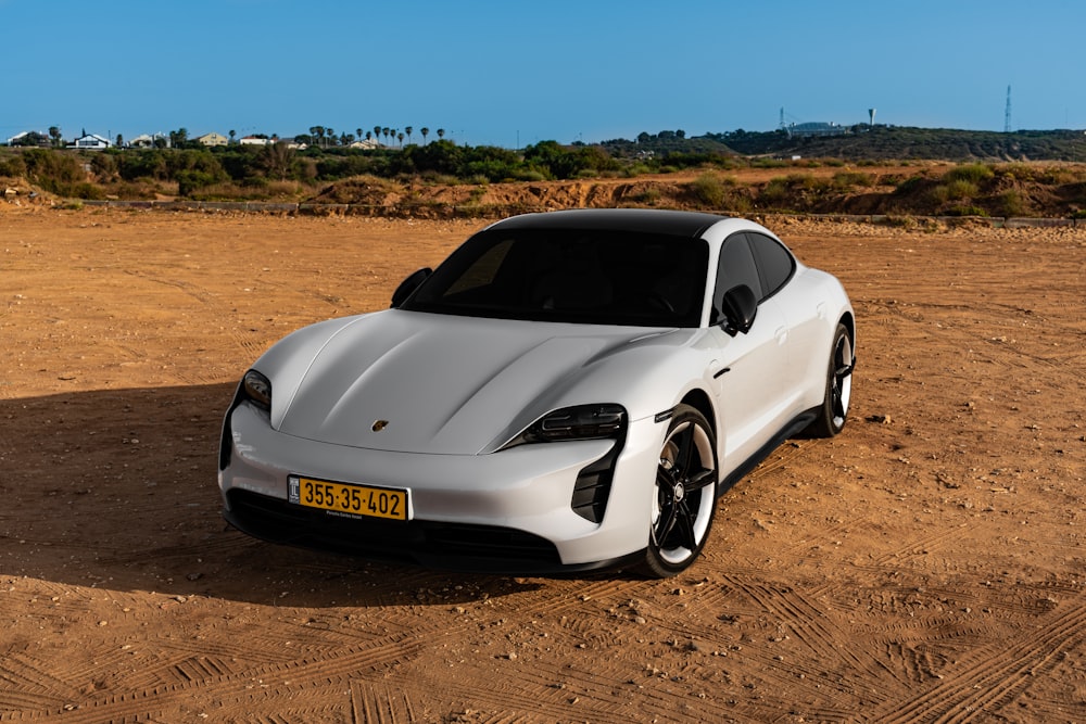 white porsche 911 on brown field during daytime