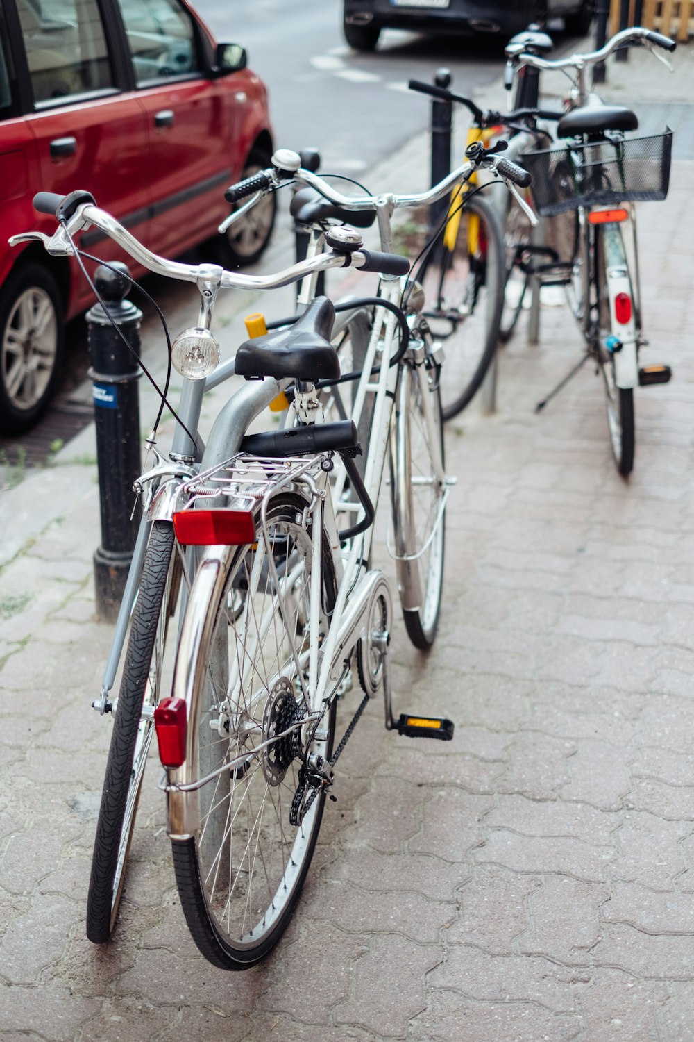 red city bike parked on sidewalk during daytime