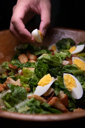 Close-up of hands preparing a healthy homemade salad with vibrant ingredients.