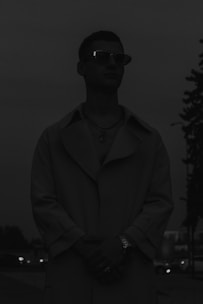 Private detective observing a subject discreetly in an urban setting at dusk.