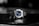 A luxury wristwatch with a metallic bracelet and a striking blue dial is centered against a blurred dark background. The watch face features silver hands and markers, presenting a modern and sophisticated design.