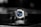 A luxury wristwatch with a metallic bracelet and a striking blue dial is centered against a blurred dark background. The watch face features silver hands and markers, presenting a modern and sophisticated design.