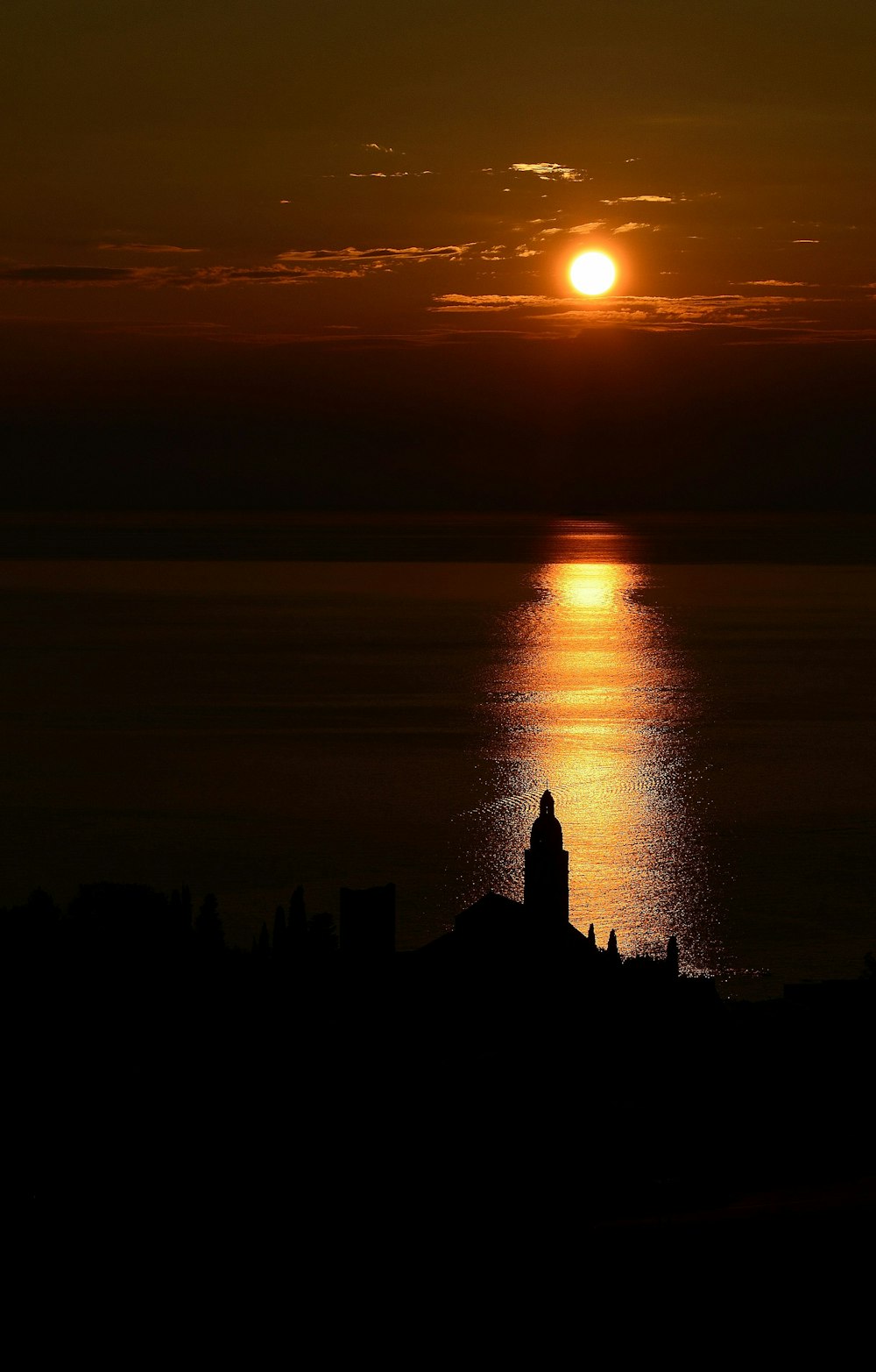 silhouette of person standing on rock formation during sunset