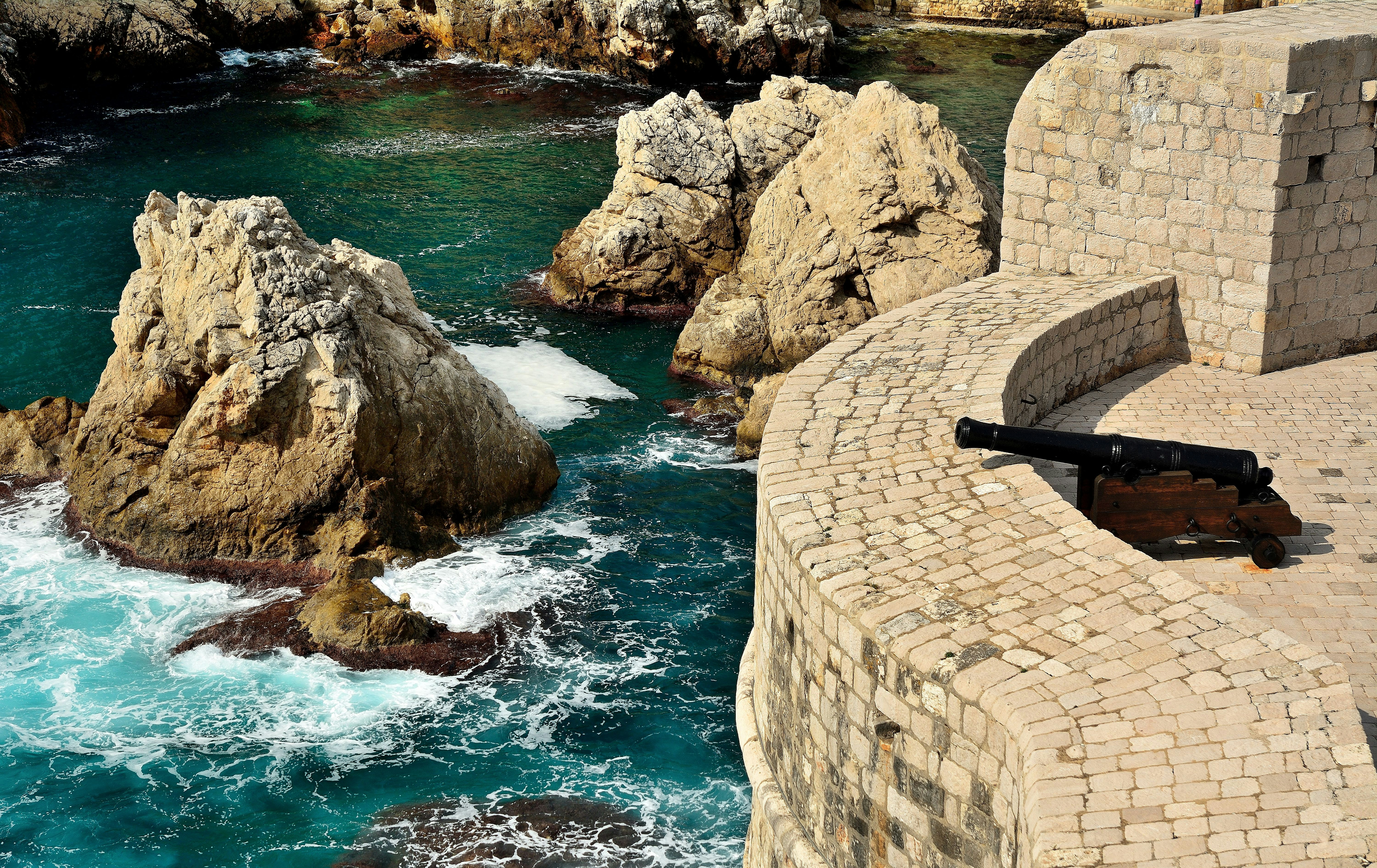 Brown brick wall near body of water during daytime