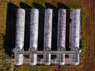 gray metal pipe lot on green grass field during daytime