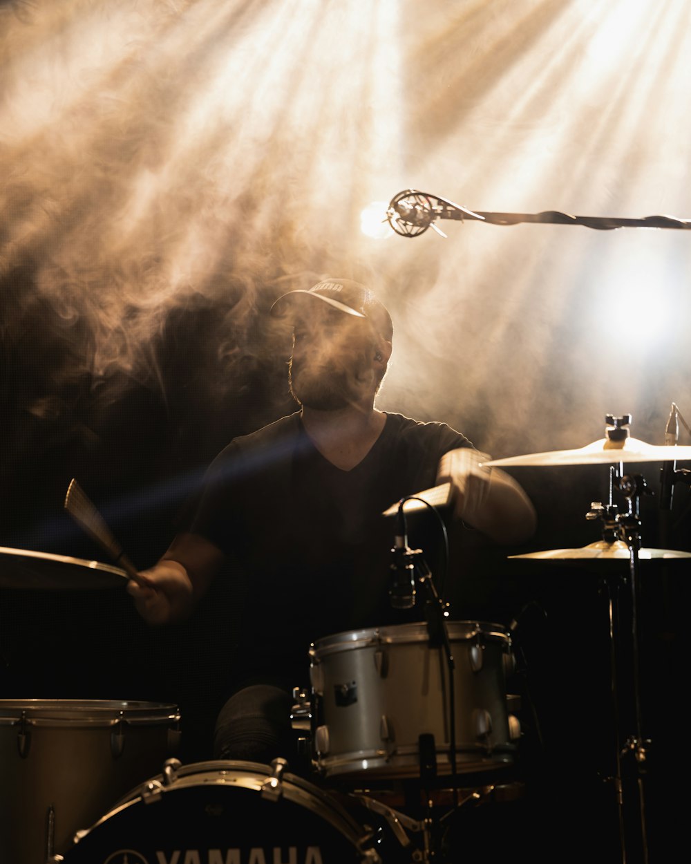 a man playing drums in front of a microphone