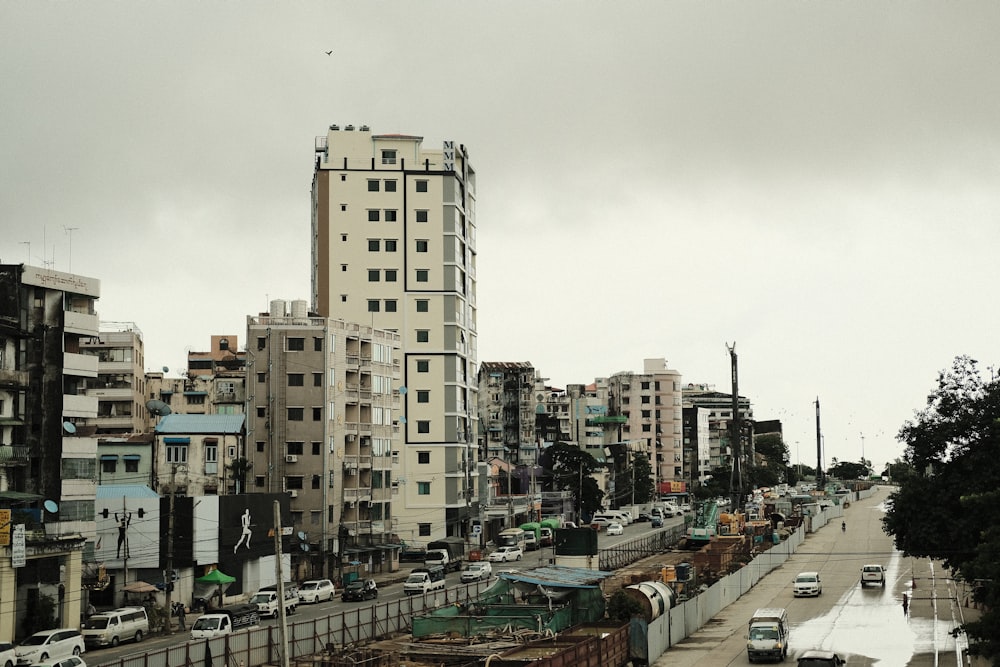 cars parked on parking lot near high rise buildings during daytime