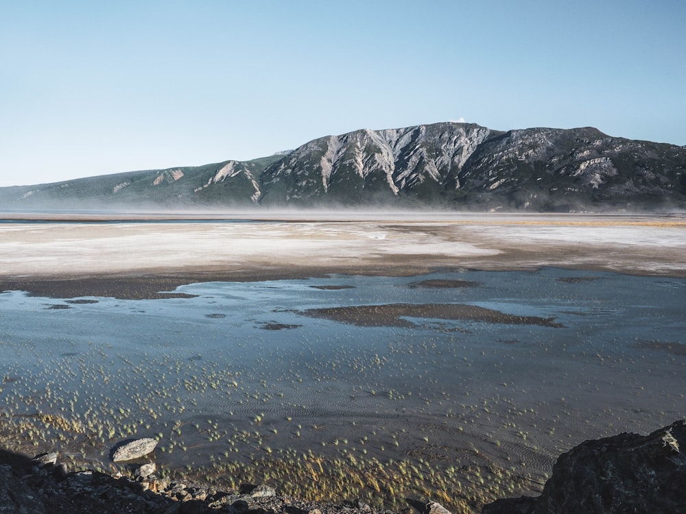 gray and white mountain near body of water during daytime