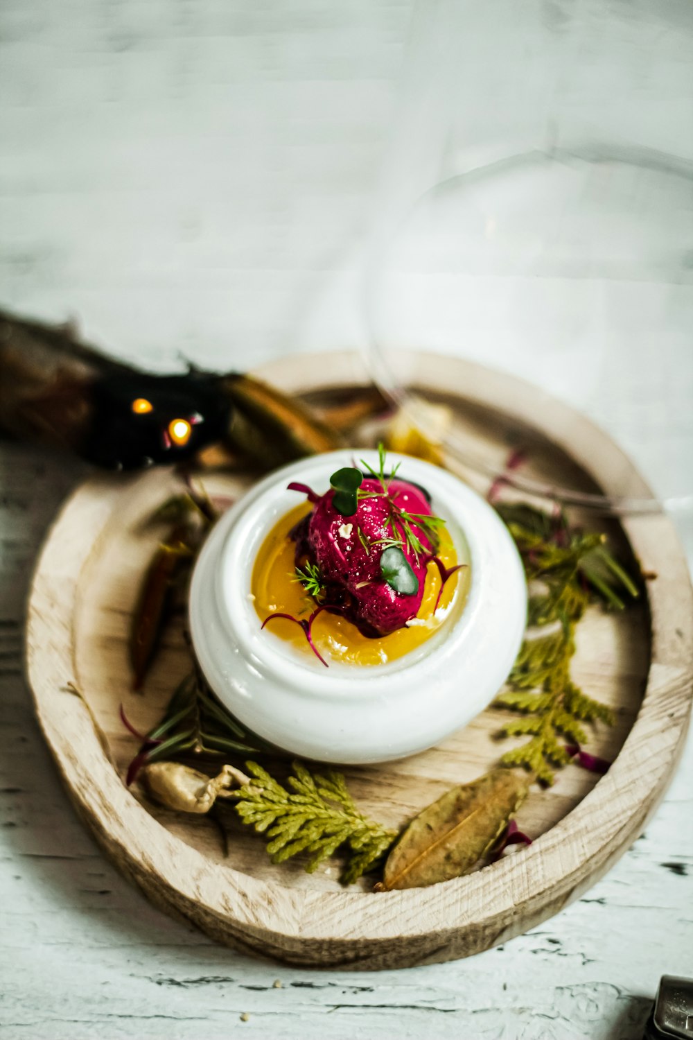 a small white bowl filled with food on top of a wooden tray