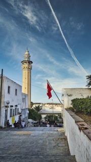 white concrete building with red flag on top during daytime