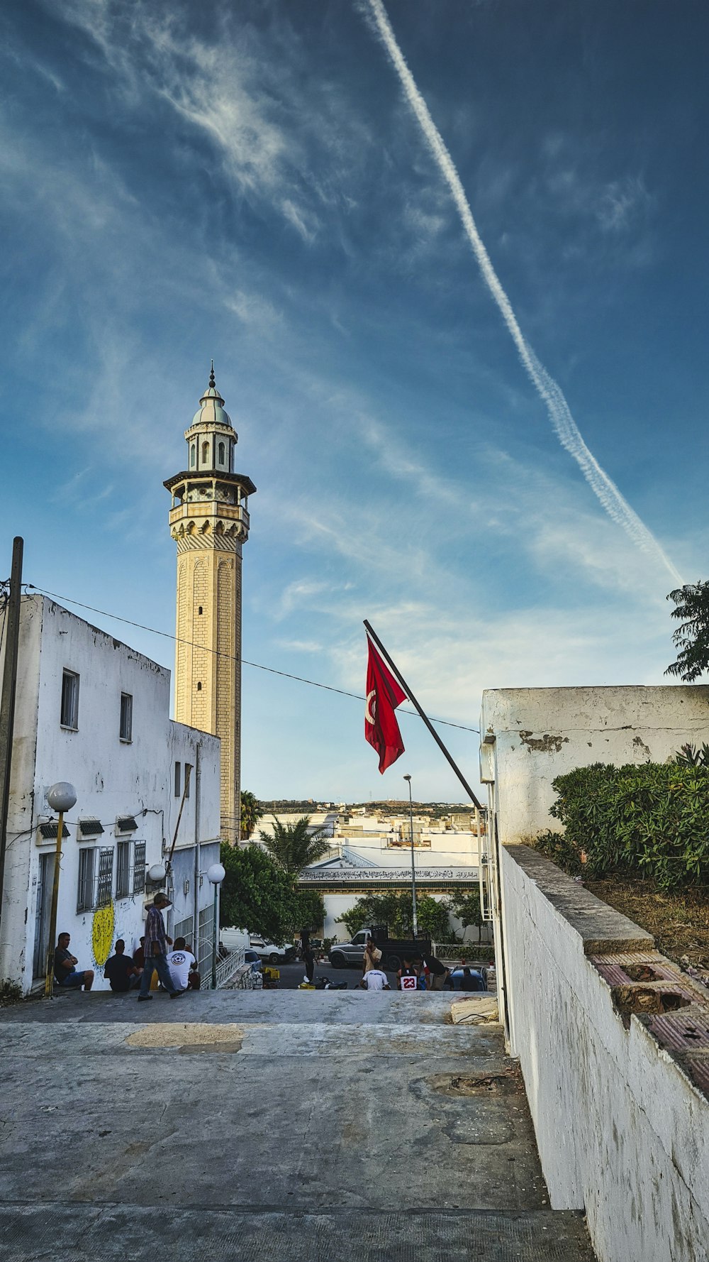 white concrete building with red flag on top during daytime