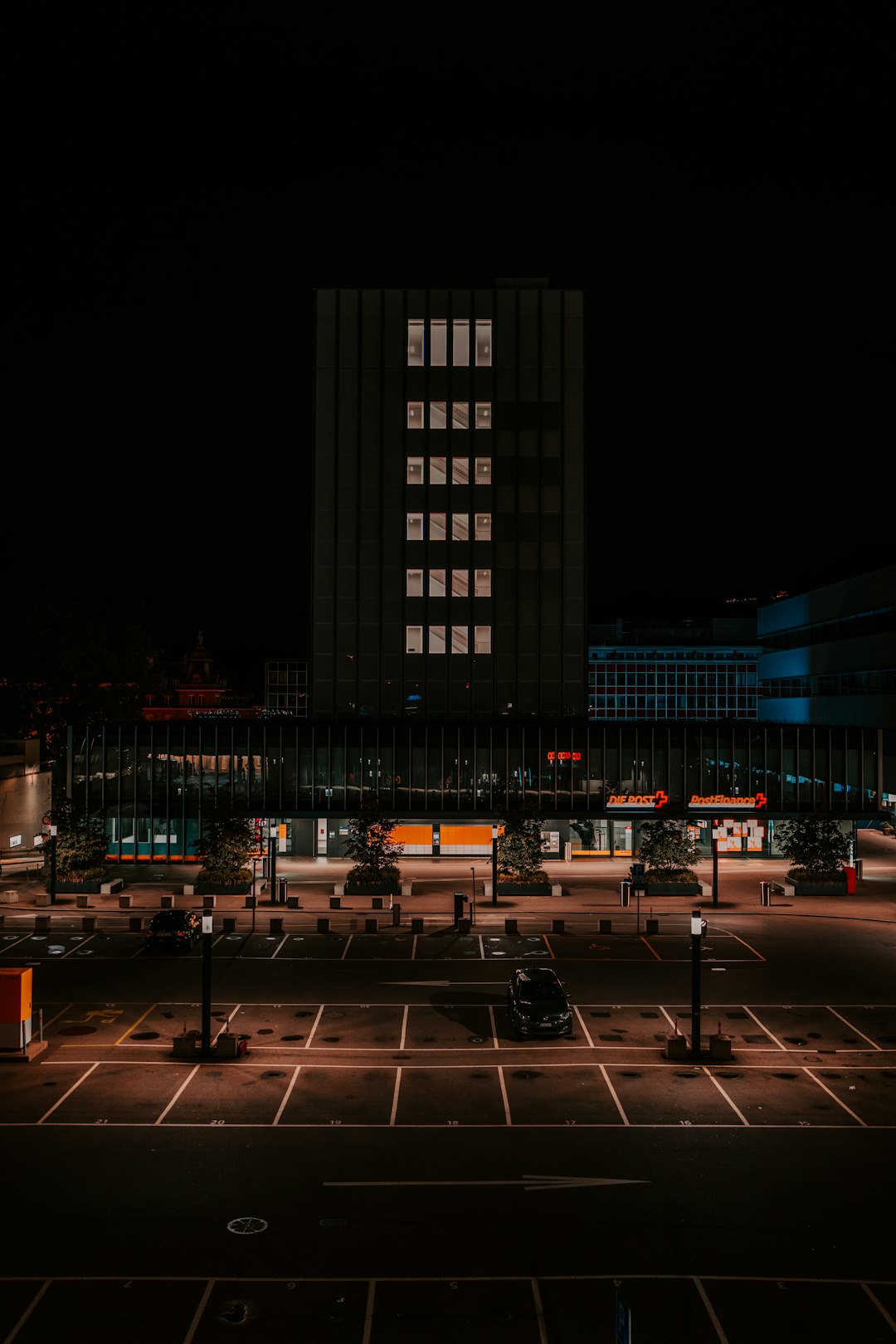 people walking on sidewalk near high rise building during night time