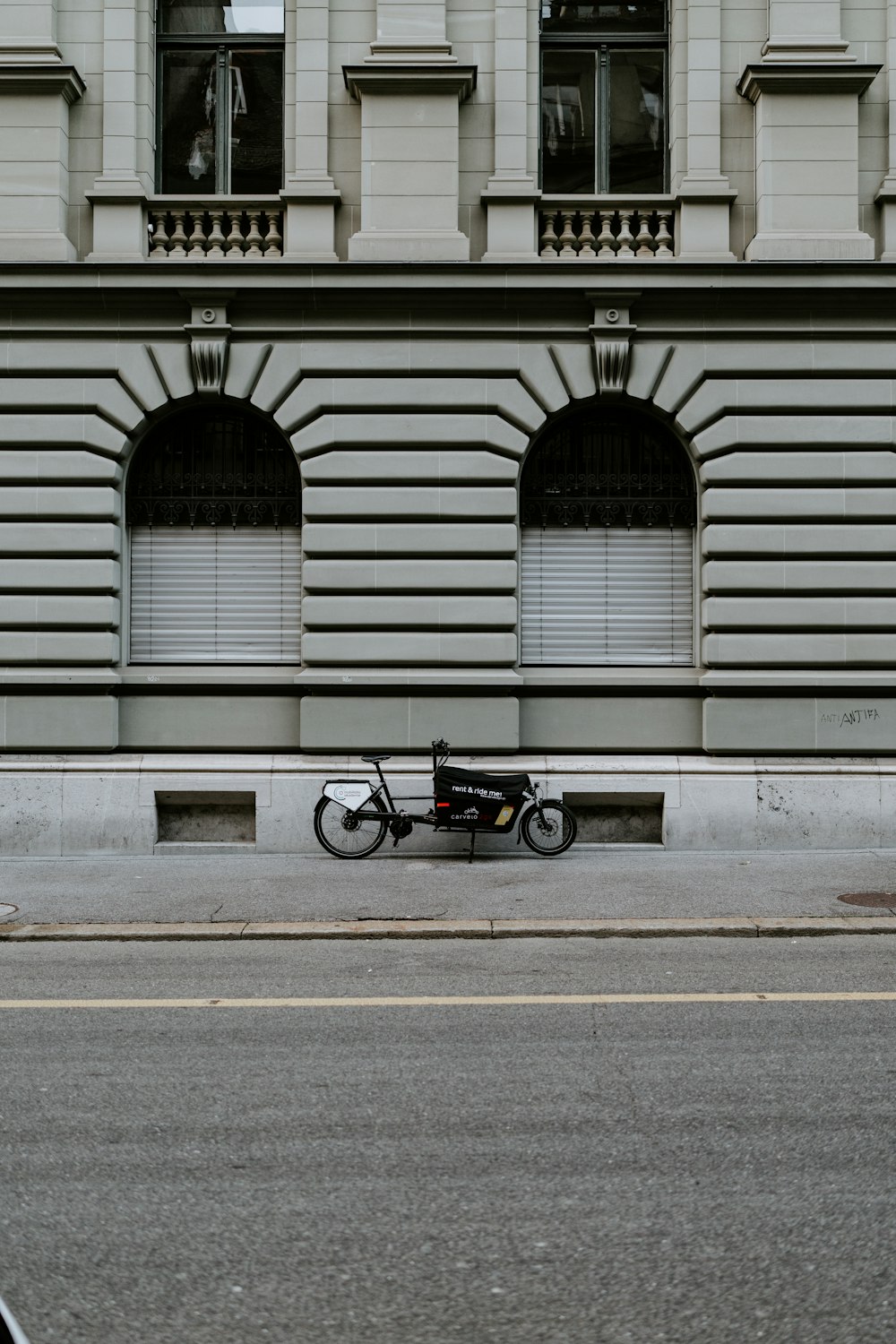 black motorcycle parked beside white building
